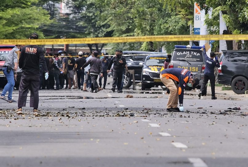 Police officers inspect the area near a church where an explosion went off in Makassar, South Sulawesi, Indonesia, Sunday, March 28, 2021. A suicide bomber blew himself up outside a packed Roman Catholic cathedral on Indonesia’s Sulawesi island during a Palm Sunday Mass, wounding a number of people, police said. (AP Photo/Masyudi S. Firmansyah)