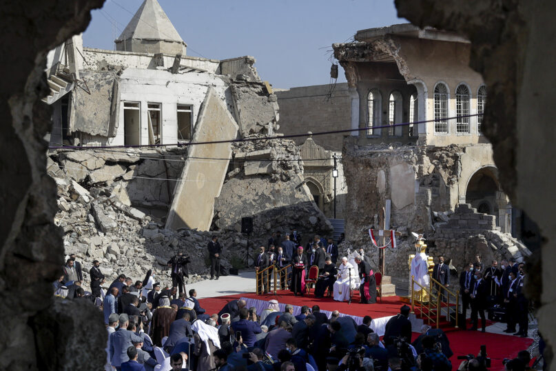 Pope Francis, surrounded by shells of destroyed churches, leads a prayer for the victims of war at Hosh al-Bieaa Church Square, in Mosul, Iraq, once the de-facto capital of IS, Sunday, March 7, 2021. The long 2014-2017 war to drive IS out left ransacked homes and charred or pulverized buildings around the north of Iraq, all sites Francis visited on Sunday. (AP Photo/Andrew Medichini)