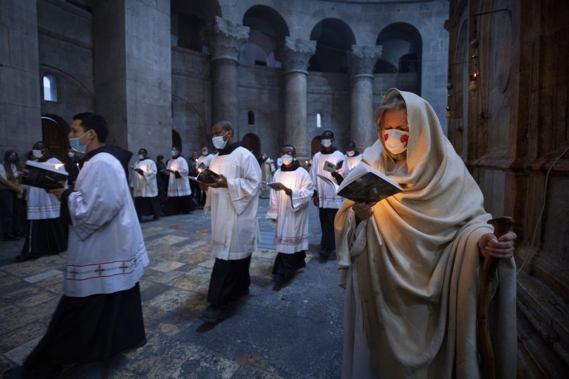 Priests circle the Edicule during Easter Sunday mass led by the Latin Patriarch at the Church of the Holy Sepulchre where Jesus Christ is believed to be buried, in the Old City of Jerusalem, Sunday, April. 4, 2021. (AP Photo/Oded Balilty)