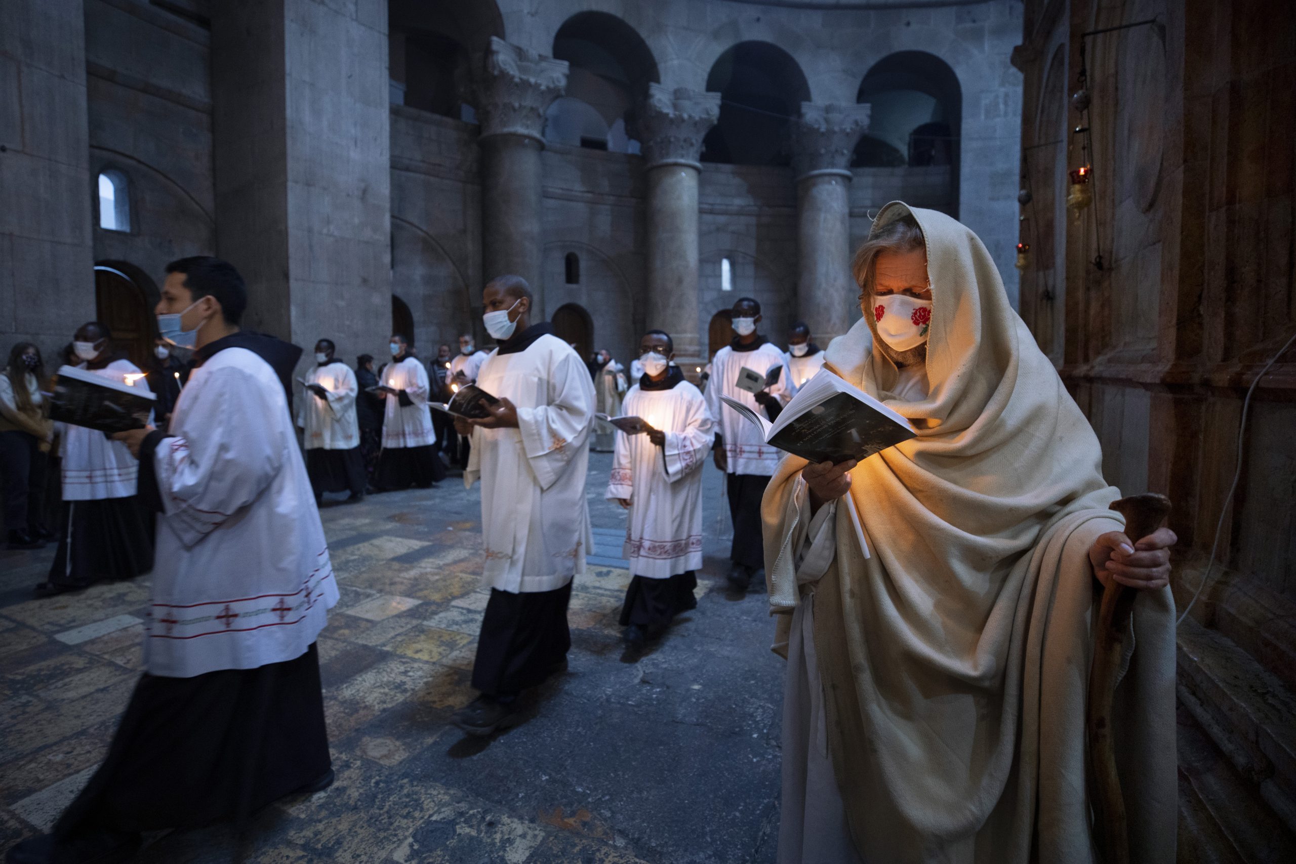 Priests circle the Edicule during Easter Sunday Mass led by the Latin Patriarch at the Church of the Holy Sepulchre, where many Christians believe Jesus was crucified, buried and rose from the dead, in the Old City of Jerusalem, Sunday, April 4, 2021. (AP Photo/Oded Balilty)