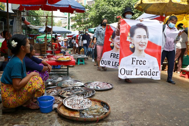 Anti-coup protesters walk through a market with images of ousted Myanmar leader Aung San Suu Kyi at Kamayut township in Yangon, Myanmar Thursday, April 8, 2021. They walked through the markets and streets of Kamayut township with slogans to show their disaffection for military coup. (AP Photo)