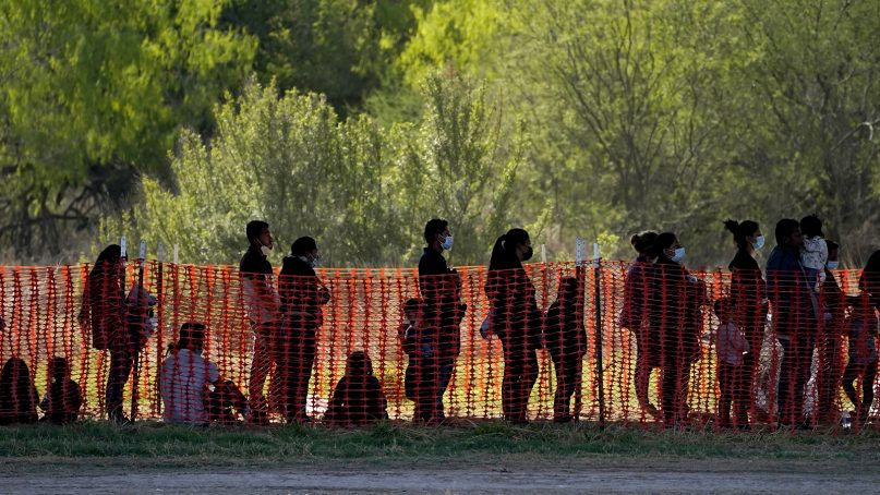 In this March 19, 2021, file photo, migrants are seen in custody at a U.S. Customs and Border Protection processing area under the Anzalduas International Bridge, in Mission, Texas. (AP Photo/Julio Cortez, File)