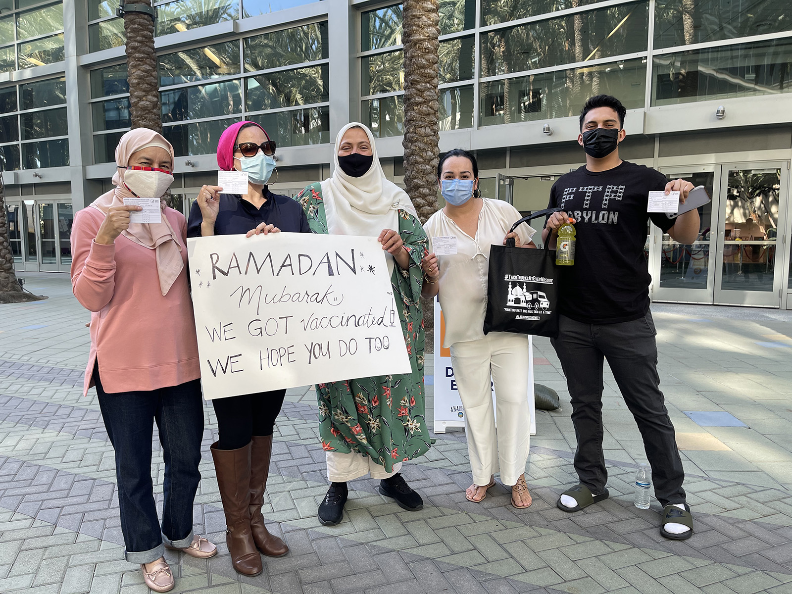 A group of Muslims display their vaccination cards and a sign reading “Ramadan Mubarak: We got vaccinated. We hope you do too,” on Sunday, April 11, 2021, at the Anaheim Convention Center in Anaheim, California. Rida Hamida, second from left, is the executive director of Latino & Muslim Unity. Photo courtesy of Latino & Muslim Unity
