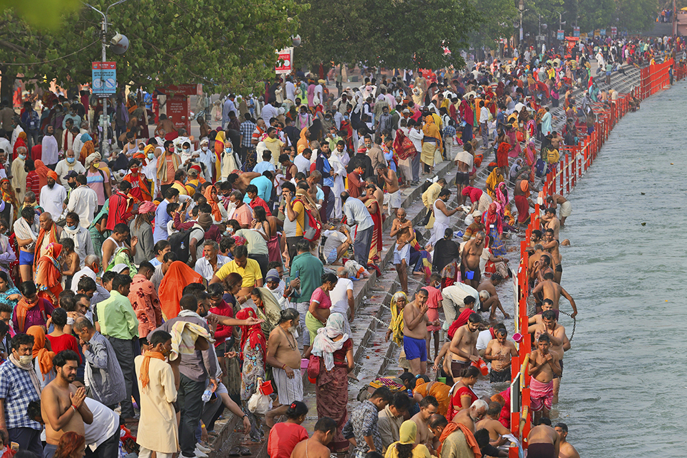 Devotees take holy dips in the river Ganges during Shahi snan, or a Royal bath at Kumbh mela, in Haridwar in the Indian state of Uttarakhand, Monday, April 12, 2021. As states across India are declaring some version of a lockdown to battle rising Covid cases as part of a nationwide second-wave, thousands of pilgrims are gathering on the banks of the river Ganga for the Hindu festival Kumbh Mela. The faithful believe that a dip in the waters of the Ganga will absolve them of their sins and deliver them from the cycle of birth and death. (AP Photo/Karma Sonam)