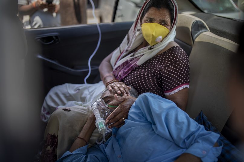 A patient breathes with the help of oxygen provided by a gurdwara, a Sikh house of worship, inside a car in New Delhi on April 24, 2021. India’s medical oxygen shortage has become so dire that this gurdwara began offering free breathing sessions with shared tanks to COVID-19 patients waiting for a hospital bed. They arrive in their cars, on foot or in three-wheeled taxis, desperate for a mask and tube attached to the precious oxygen tanks outside the gurdwara in a neighborhood outside New Delhi. (AP Photo/Altaf Qadri)