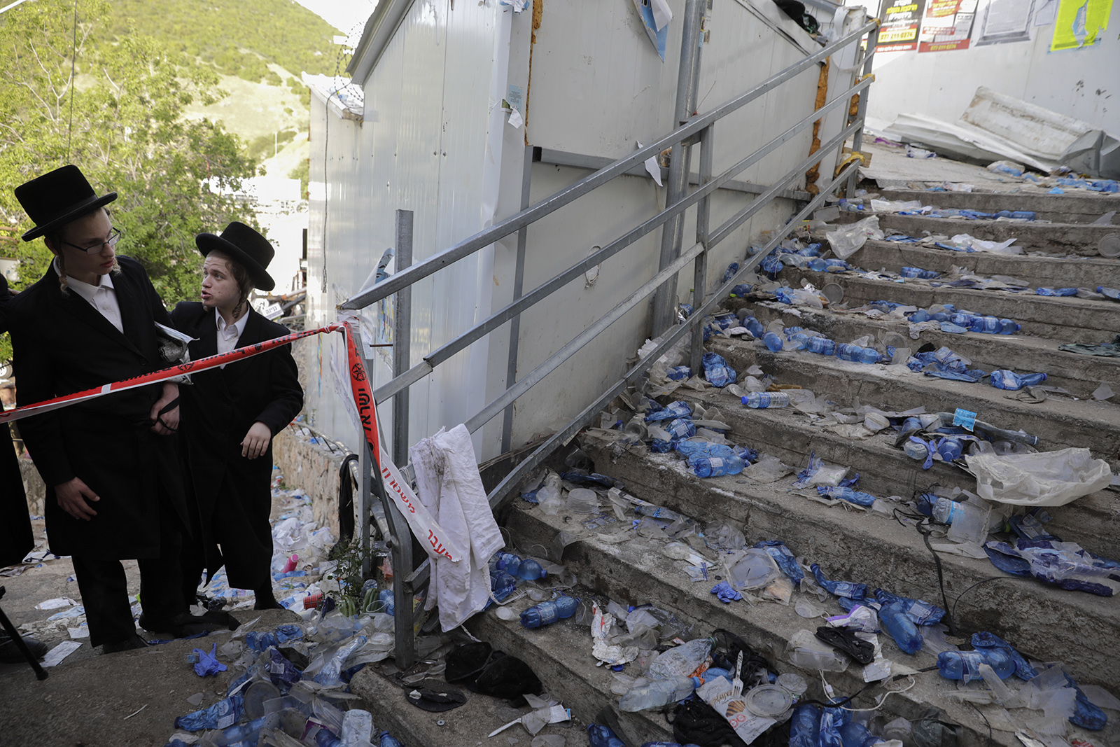 Ultra-Orthodox Jews look at the scene where fatalities were reported among the thousands of ultra-Orthodox Jews during the Lag b’Omer festival at Mount Meron in northern Israel, Friday, April 30, 2021. A stampede at the religious festival attended by tens of thousands of ultra-Orthodox Jews in northern Israel killed dozens of people and injured more than 100 others early Friday, medical officials said, in one of the country's deadliest civilian disasters. (AP Photo/Sebastian Scheiner)