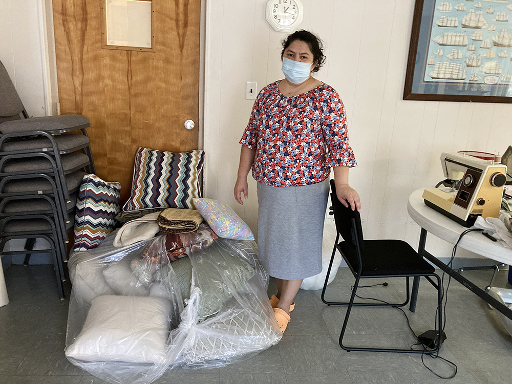 Juana Luz Tobar Ortega poses beside a bag filled with pillows she has sewed at St. Barnabas Episcopal Church in Greensboro, North Carolina, Friday, April 16, 2021. Ortega has spent nearly four years in sanctuary at St. Barnabas Episcopal Church. RNS photo by Yonat Shimron