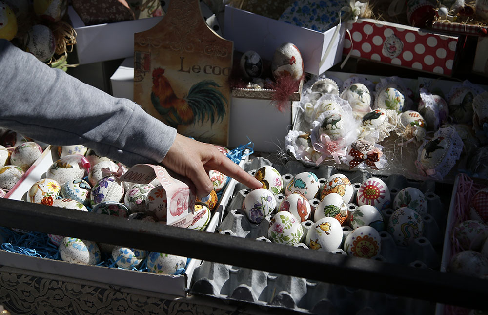 A buyer chooses hand decorated Easter eggs at a market in Belgrade, Serbia, Friday, April 30, 2021. Orthodox Serbs celebrate Easter on May 2, according to the Julian calendar. (AP Photo/Darko Vojinovic)