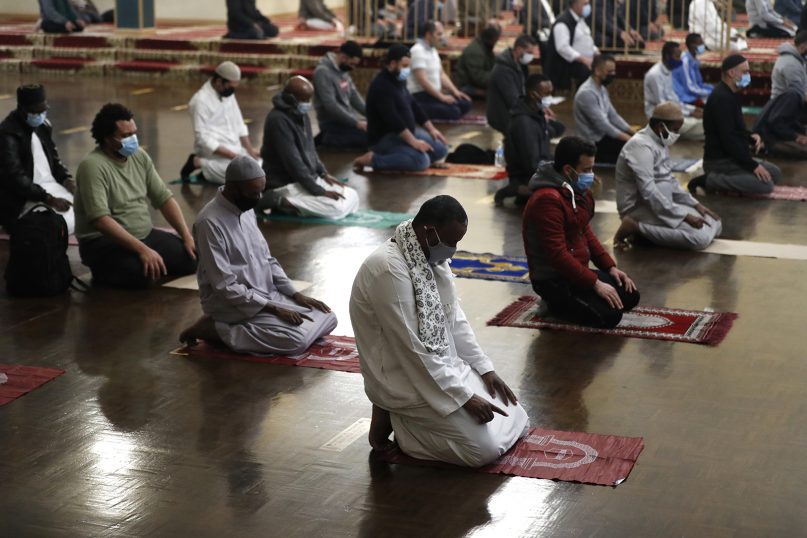 Muslims pray as they practice social distancing during an evening prayer called tarawih, marking the first eve of the holy fasting month of Ramadan at Chicago's Muslim Community Center on April 12, 2021. (AP Photo/Shafkat Anowar)