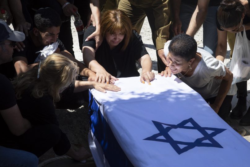 Relatives of Israeli soldier Omer Tabib, 21, mourn during his funeral at the cemetery in the northern Israeli town of Elyakim, Thursday, May 13, 2021. The Israeli army confirmed that Tabib was killed in an anti-tank missile attack near the Gaza Strip, the first Israeli military death in the current fighting between Israelis and Palestinians. (AP Photo/Sebastian Scheiner)