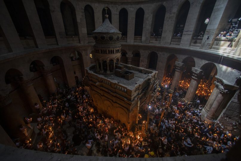 Christian pilgrims hold candles as they gather during the ceremony of the Holy Fire at Church of the Holy Sepulchre, where many Christians believe Jesus was crucified, buried and rose from the dead, in the Old City of Jerusalem, Saturday, May 1, 2021. Hundreds of Christian worshippers took use of Israel's easing of coronavirus restrictions Saturday and packed a Jerusalem church revered as the site of Jesus' crucifixion and resurrection for an ancient fire ceremony ahead of Orthodox Easter. (AP Photo/Ariel Schalit)