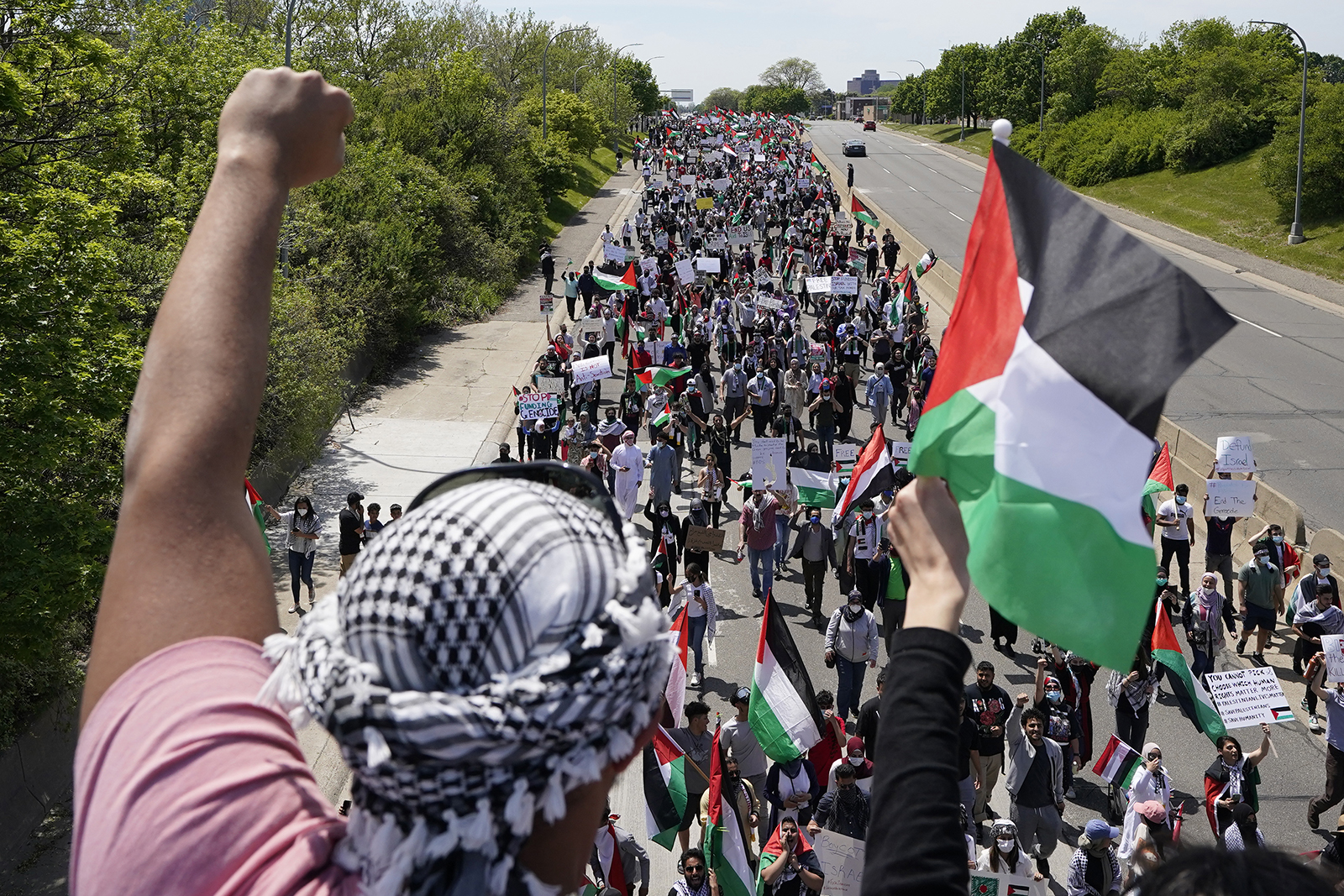 Protesters supporting Palestinians walk down Michigan Ave., as President Joe Biden visits a Ford electric vehicle center nearby, Tuesday, May 18, 2021, in Dearborn, Mich. Biden’s efforts to spotlight his big infrastructure plans are suddenly being overshadowed by the escalating violence between Israel and the Palestinians. (AP Photo/Carlos Osorio)