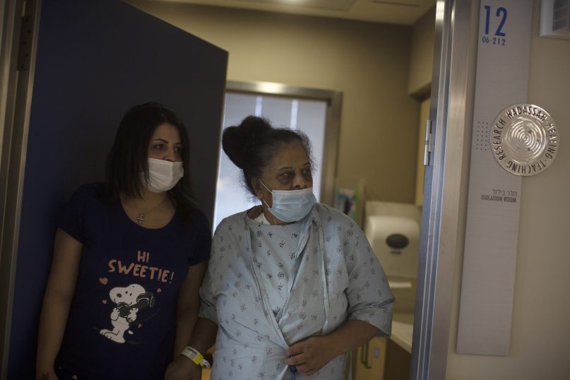 Randa Aweis, right, who received a kidney transplant from Yigal Yehoshua, a Jewish man who died May 17 after being pelted with rocks amid clashes between Arabs and Jews in Israel’s mixed city of Lod, walks with her daughter Nevine at Hadassah Ein Karem Hospital in Jerusalem on May 24, 2021. (AP Photo/Maya Alleruzzo)