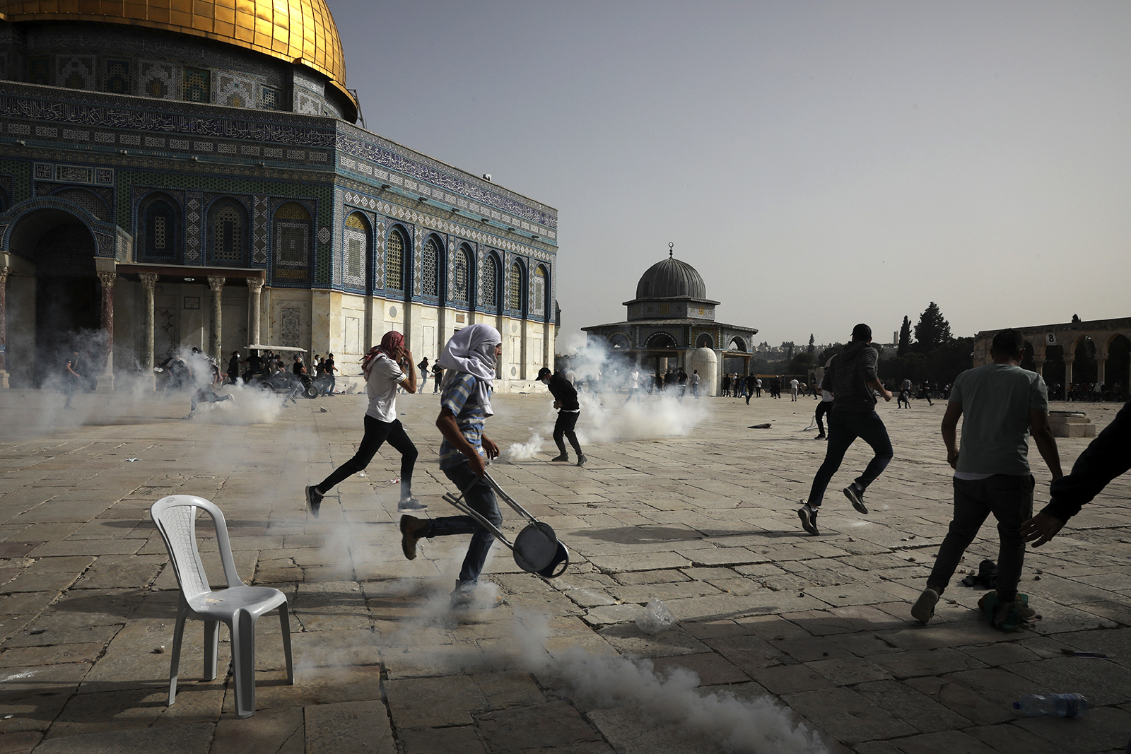 Palestinians run away from tear gas during clashes with Israeli security forces May 10, 2021, at the Al-Aqsa Mosque compound in Jerusalem's Old City. Israeli police clashed with Palestinian protesters at the holy site in the latest in a series of confrontations that are pushing the contested city to the brink of eruption. (AP Photo/Mahmoud Illean)