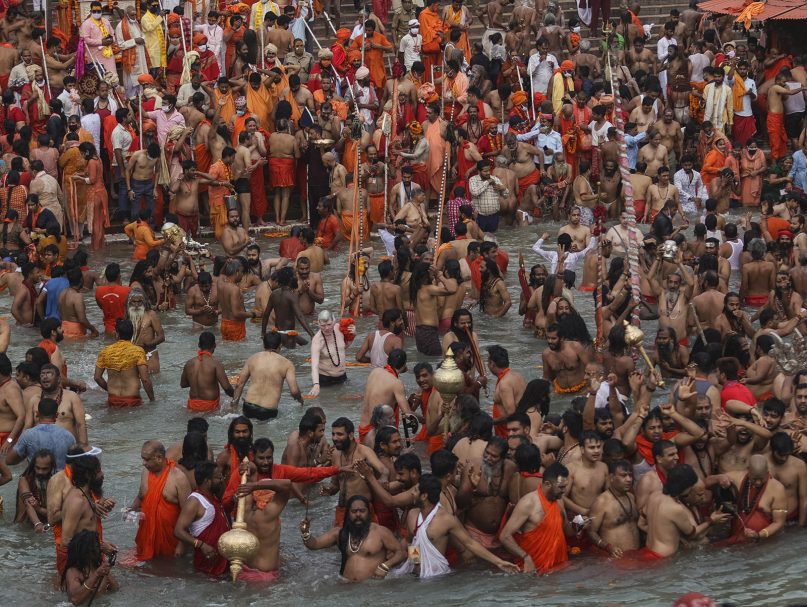 Devotees take holy dips in the Ganges River during Kumbh Mela, or pitcher festival, one of the most sacred pilgrimages in Hinduism, in Haridwar, northern state of Uttarakhand, India, Monday, April 12, 2021. Tens of thousands of Hindu devotees gathered by the Ganges River for special prayers Monday, many of them flouting social distancing practices as the coronavirus spreads in India with record speed. (AP Photo/Karma Sonam)
