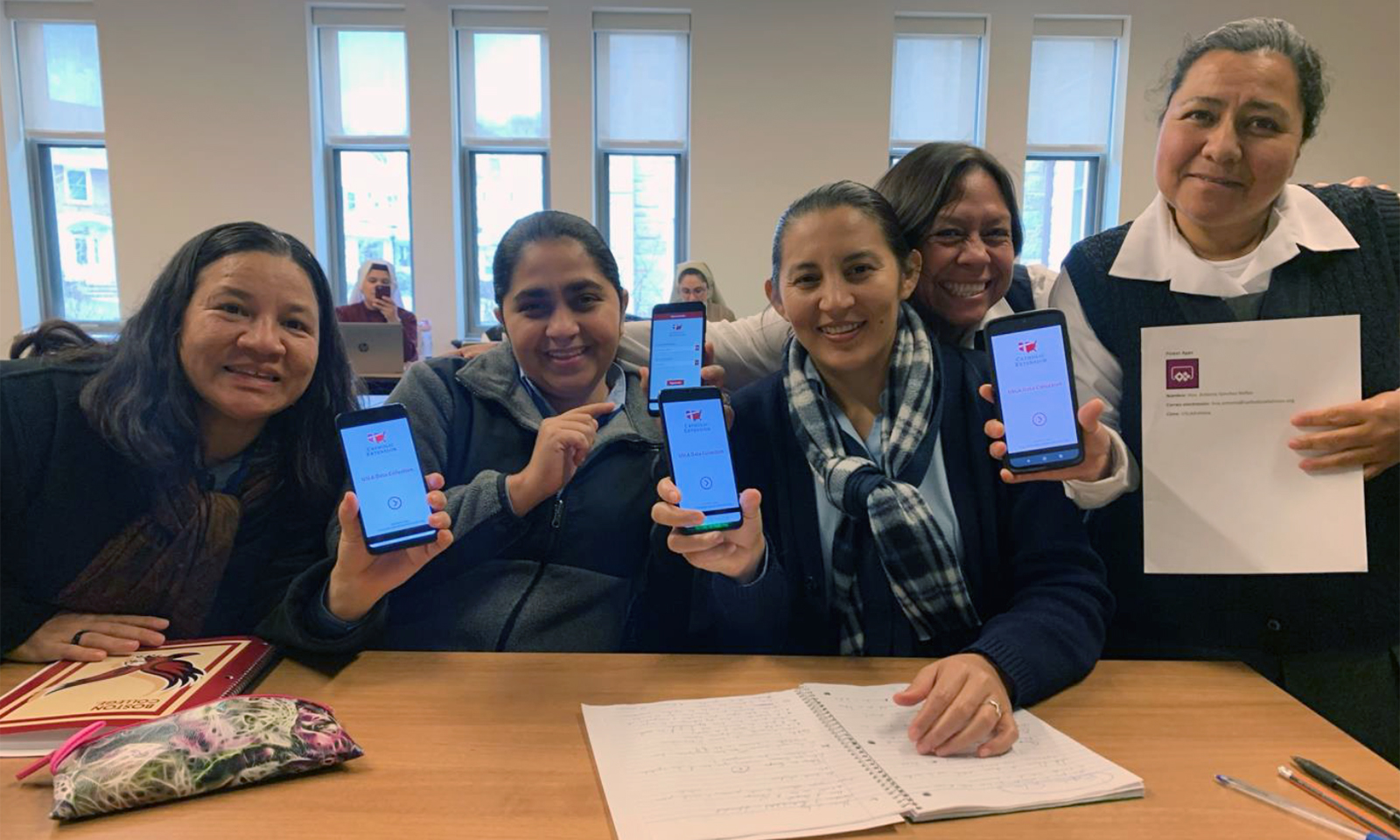 A group of nuns pose with their phones during a 2020 training session for the app developed by Catholic Extension. Photo courtesy of Catholic Extension