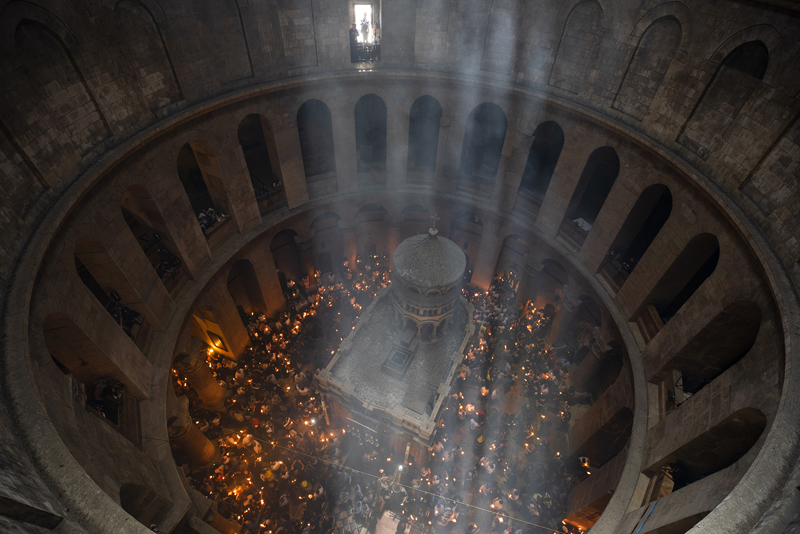 Christian pilgrims hold candles as they gather during the ceremony of the Holy Fire at Church of the Holy Sepulchre, where many Christians believe Jesus was crucified, buried and rose from the dead, in the Old City of Jerusalem, Saturday, May 1, 2021. Thousands of Christians have gathered in Jerusalem for the ancient fire ceremony that celebrates Jesus' resurrection. (AP Photo/Oded Balilty)