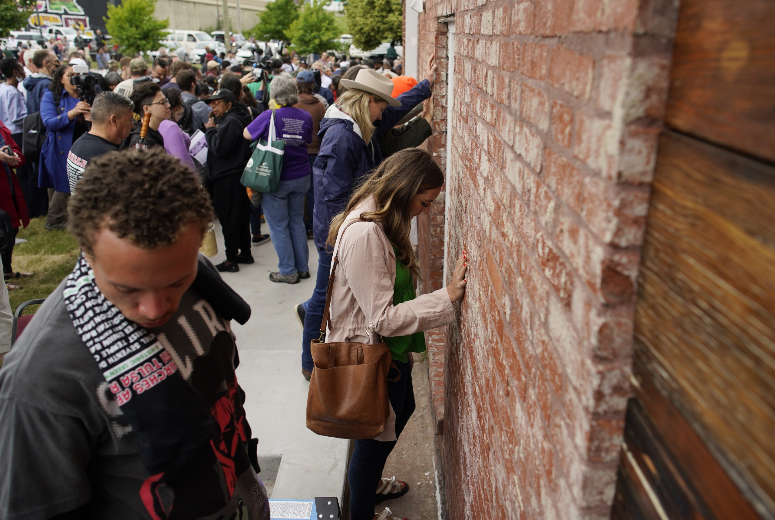 People hold their hands on a prayer wall outside of the historic Vernon African Methodist Episcopal Church in the Greenwood neighborhood during the centennial of the Tulsa Race Massacre, Monday, May 31, 2021, in Tulsa, Okla. The church was largely destroyed when a white mob descended on the prosperous Black neighborhood in 1921, burning, killing, looting and leveling a 35-square-block area. (AP Photo/John Locher)