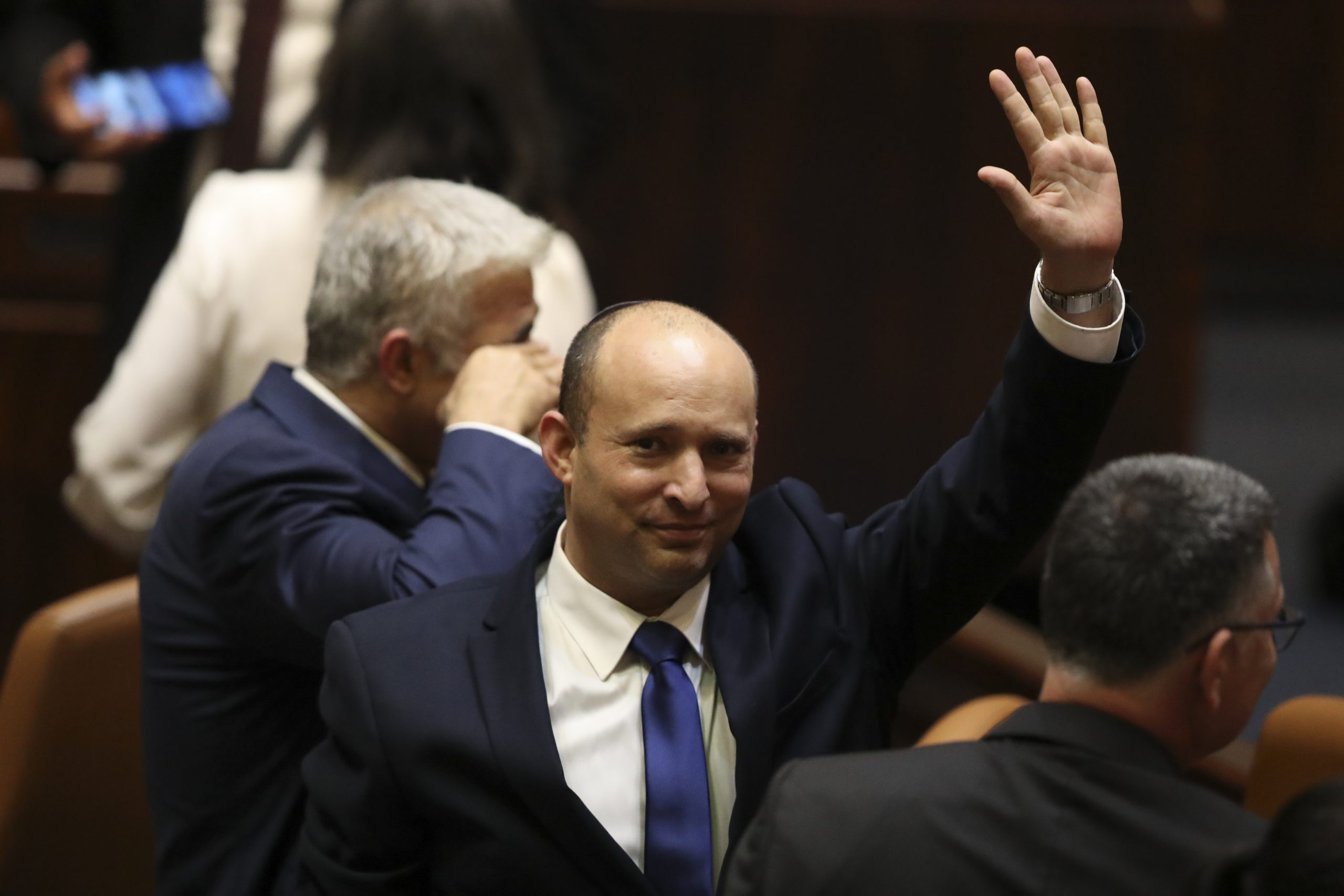 Israel's new prime minister Naftali Bennett raises his hand during a Knesset session in Jerusalem Sunday, June 13, 2021. Israel's parliament has voted in favor of a new coalition government, formally ending Prime Minister Benjamin Netanyahu's historic 12-year rule. Naftali Bennett, a former ally of Netanyahu became the new prime minister (AP Photo/Ariel Schalit)