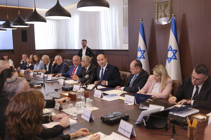Israeli Prime Minister Naftali Bennett, center, chairs the first weekly cabinet meeting of the new government in Jerusalem, Sunday, June 20, 2021. Bennett opened his first Cabinet meeting on Sunday since swearing in his new coalition government with a condemnation of the newly elected Iranian president, whom he called “the hangman of Tehran.” (Emmanuel Dunand/Pool Photo via AP)