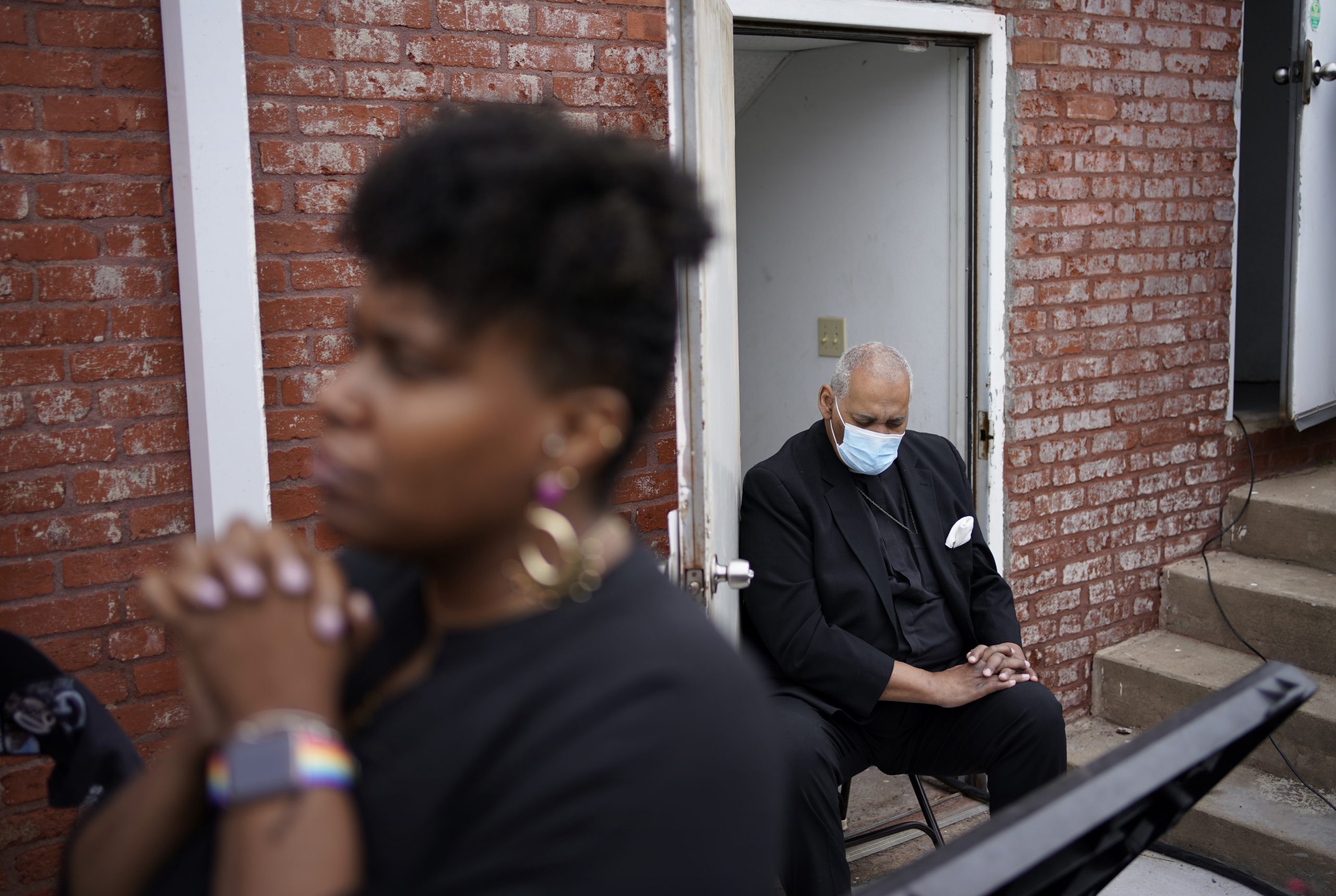 People pray during the dedication of a prayer wall at the historic Vernon African Methodist Episcopal Church in the Greenwood neighborhood during the centennial of the Tulsa Race Massacre, Monday, May 31, 2021, in Tulsa, Okla. The church was largely destroyed when a white mob descended on the prosperous Black neighborhood in 1921, burning, killing, looting and leveling a 35-square-block area. (AP Photo/John Locher)