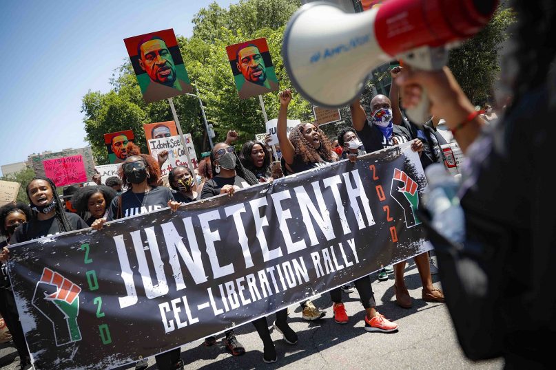 FILE - In this Friday, June 19, 2020, file photo, demonstrators protest during a Juneteenth rally at the Brooklyn Museum, in Brooklyn, N.Y. President Joe Biden signed into law Thursday, June 17, 2021, a bill designating Juneteenth—which commemorates June 19, 1865 when enslaved people in Texas learned they had been freed—as the 11th federal holiday. (AP Photo/John Minchillo, File)