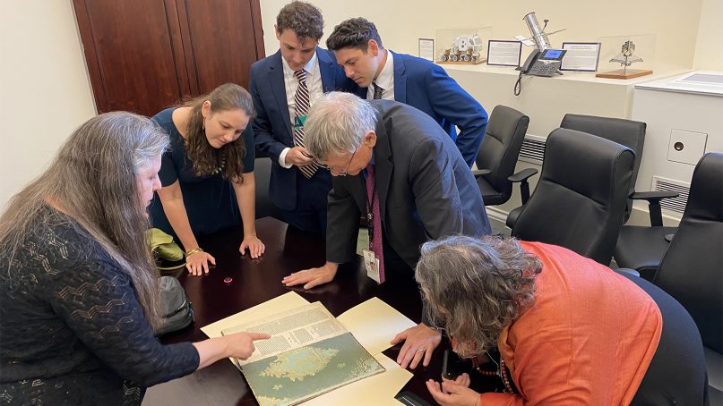 Library of Congress specialist Ann Brener, left, shows incoming White House Office of Science and Technology Policy Director Eric Lander and his family a 500-year-old copy of the Pirkei Avot shortly before he used it during his swearing-in ceremony on June 2, 2021. (Photo courtesy of the White House Office of Science and Technology Policy)