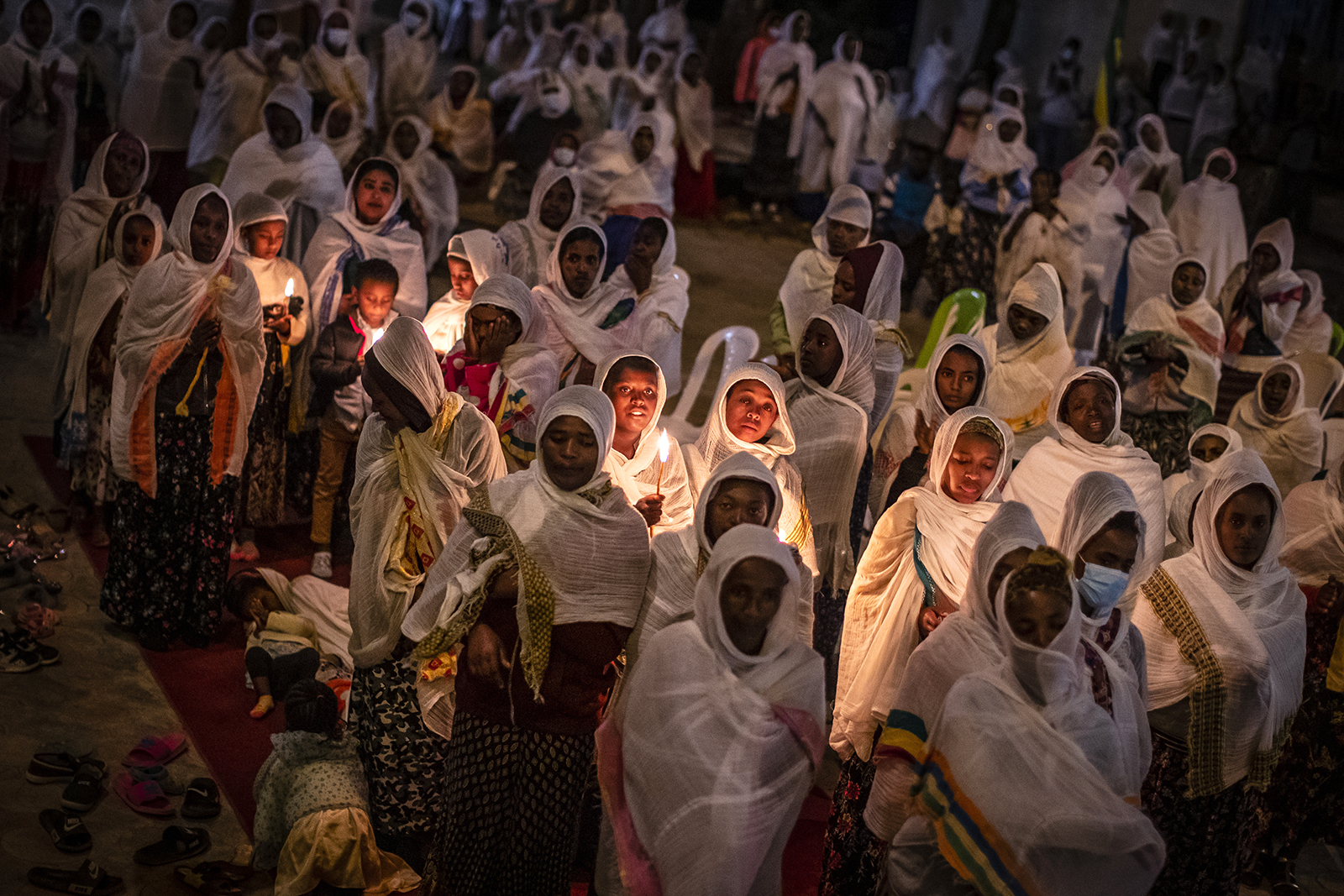 Ethiopian Orthodox Christians hold candles to celebrate Senay Mikael's Feast, or St. Michael's Day, as they listen to a sermon at St. Michael's Church in the Intoto neighborhood on the outskirts of Addis Ababa, in Ethiopia, Saturday June 19, 2021. In addition to celebrating the feast, the priests prayed for peace in the country and in the upcoming elections.  (AP Photo / Ben Curtis)