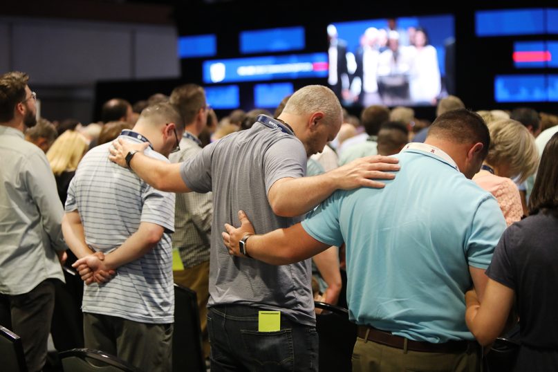 Messengers pray together during the annual meeting of the Southern Baptist Convention, June 15, 2021, at the Music City Center in Nashville, Tennessee. RNS photo by Kit Doyle