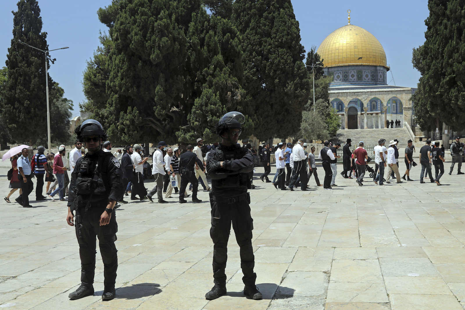 Israeli policemen stand guard as Jewish men visit the Dome of the Rock Mosque within the grounds of the Al-Aqsa Mosque in the Old City of Jerusalem during the fasting mourning ritual of Tisha Be Av (Ninth Av) and a memorial day, commemorating the destruction of ancient temples in Jerusalem, Sunday, July 18, 2021. (AP Photo / Mahmoud Illean)