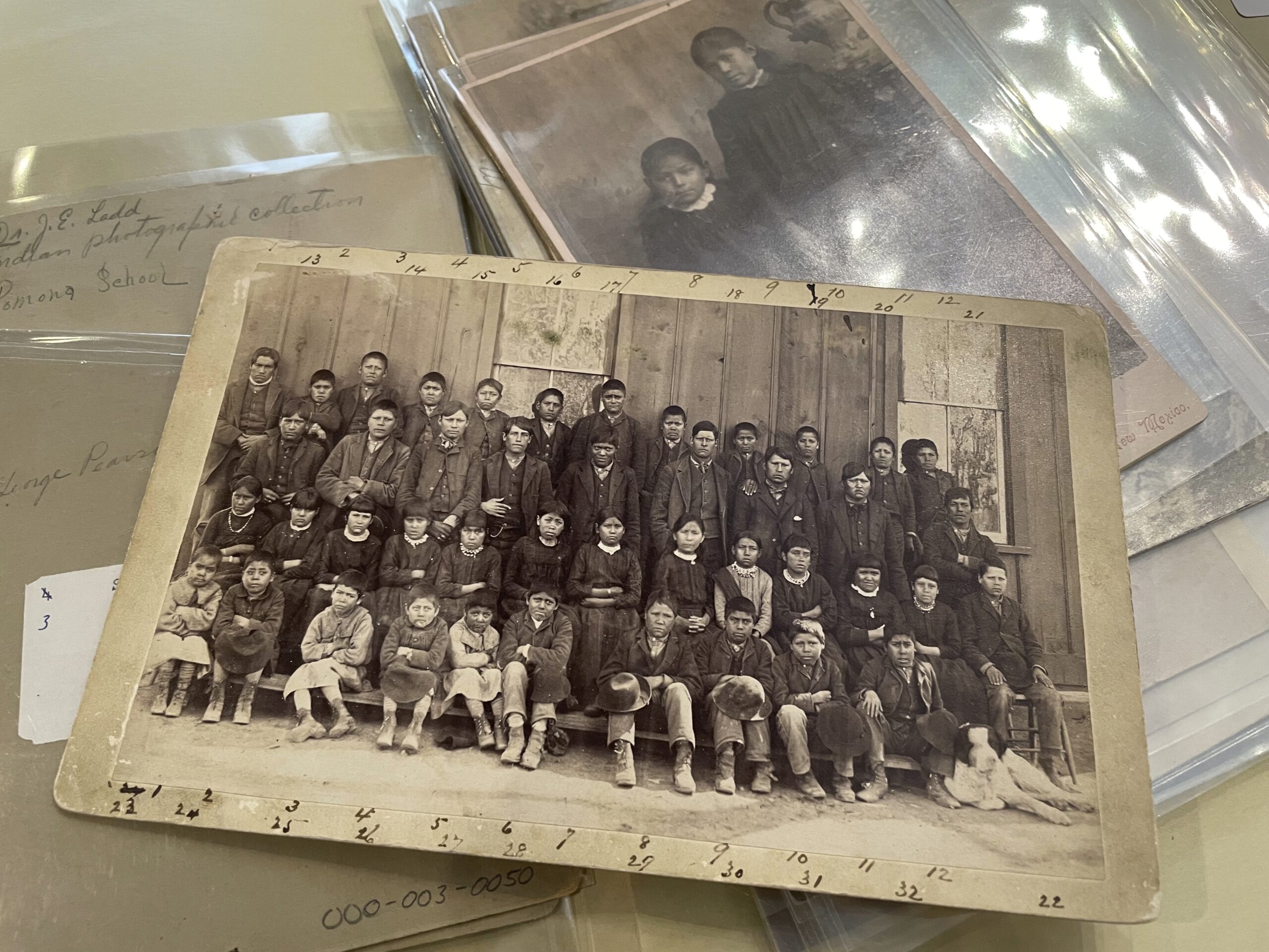 This July 8, 2021 image of a photograph archived at the Center for Southwest Research at the University of New Mexico in Albuquerque, New Mexico, shows a group of Indigenous students who attended the Ramona Industrial School in Santa Fe. The late 19th century image is among many in the Horatio Oliver Ladd Photograph Collection that are related to the boarding school. (AP Photo/Susan Montoya Bryan)