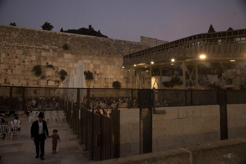 The wooden bridge, right, connecting the Western Wall, the holiest site where Jews can pray, to the Al Aqsa Mosque compound in Jerusalem's Old City, Tuesday, July 20, 2021. Experts say the rickety bridge that allows access to the Holy Land's most sensitive religious site is at imminent risk of collapse. But the shrine's delicate position at the epicenter of the Israeli-Palestinian conflict prevents it from being repaired -- raising fears of another disaster just months after 45 people were killed in a stampede at an ultra-Orthodox Jewish shrine where organizers had also ignored years of safety warnings. (AP Photo/Maya Alleruzzo)