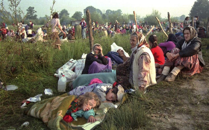 FILE - In this July 14, 1995, file photo, refugees from Srebrenica who had spent the night in the open air, gather outside the U.N. base at Tuzla airport. Twenty-six years after the July 1995 Srebrenica massacre, the only episode of Bosnia’s 1992-95 war to be legally defined as genocide, its survivors continue to grapple with the horrors they endured while also confronting increasingly aggressive downplaying and even denial of their ordeal. (AP Photo/Darko Bandic, File)
