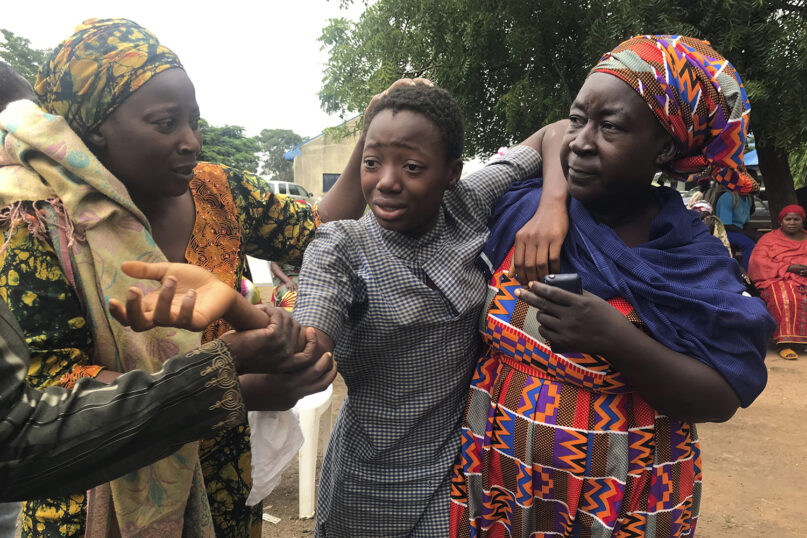 A student who was abducted and then released is reunited with her family at the Bethel Baptist High School in Damishi, Nigeria, on July 25, 2021. Armed kidnappers in Nigeria have released 28 of the more than 120 students who were abducted at the beginning of July from the Bethel Baptist High School in the northern town of Damishi. Church officials handed those children over to their parents at the school on Sunday. (AP Photo)
