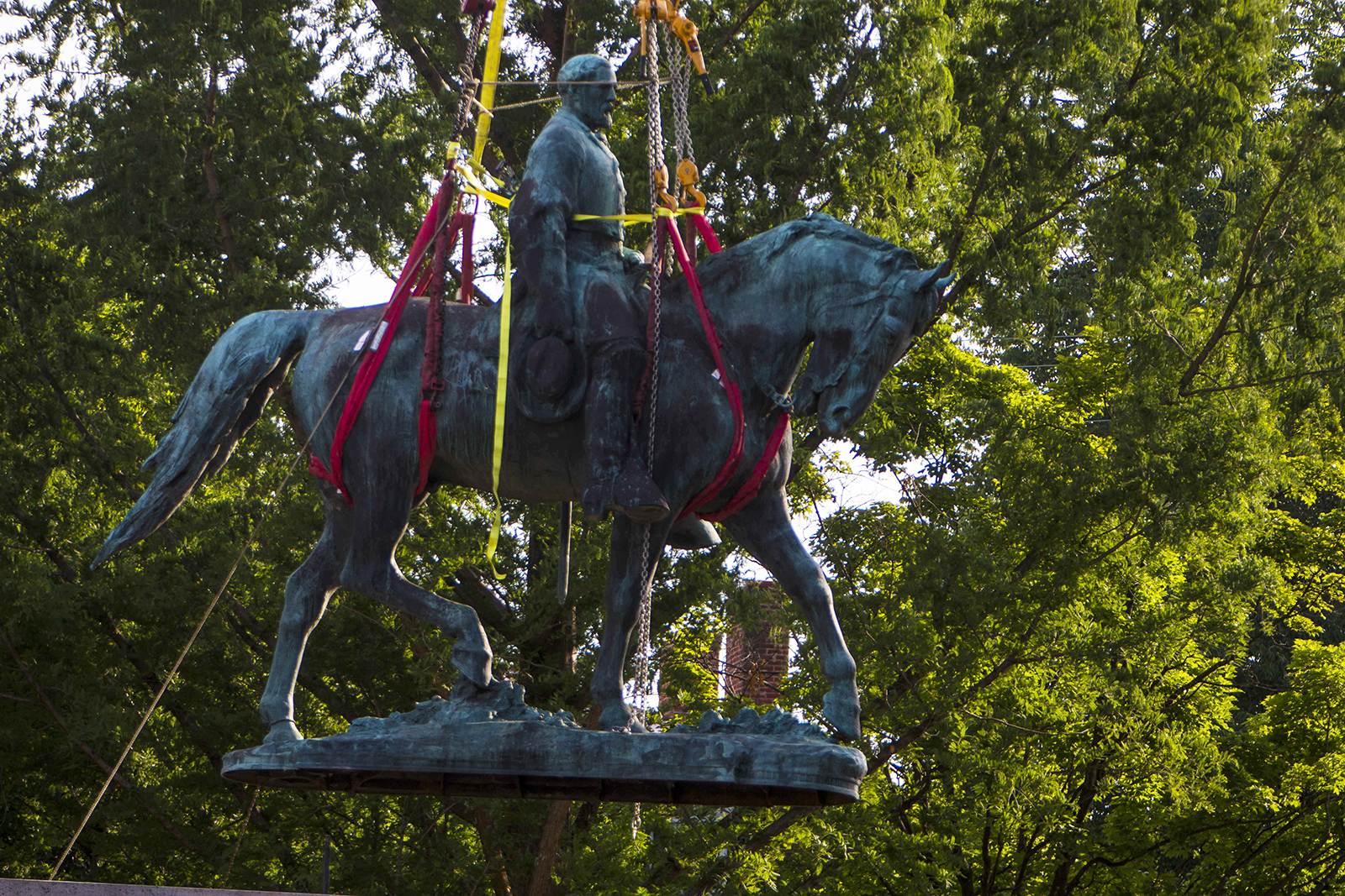 Workers remove the monument of Confederate General Robert E. Lee on Saturday, July 10, 2021 in Charlottesville, Va. The removal of the Lee statue follows years of contention, community anguish and legal fights. (AP Photo/John C. Clark)