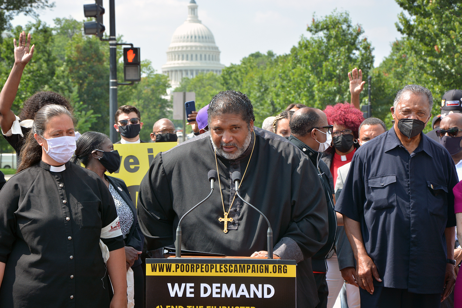 The Rev. William Barber, center, flanked by the Rev. Liz Theoharis, left, and the Rev. Jesse Jackson, right, speaks during a Poor People's Campaign demonstration in Washington, Monday, Aug. 2, 2021. RNS photo by Jack Jenkins