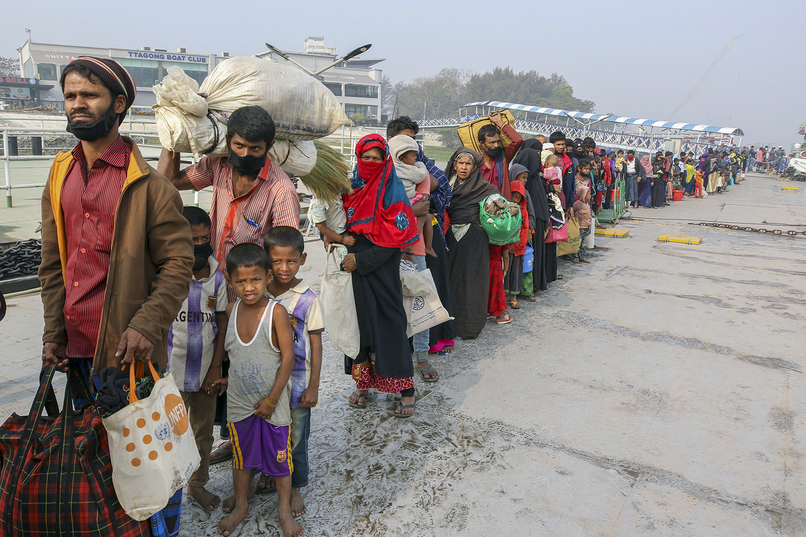 In this Feb. 15, 2021, file photo, Rohingya refugees headed to the Bhasan Char island prepare to board navy vessels from the southeastern port city of Chattogram, Bangladesh. Authorities in Bangladesh on Aug. 10, 2021, started vaccinating Rohingya refugees against coronavirus for the first time across massive camps where more than 1 million refugees from neighboring Myanmar have been sheltered, officials and the U.N. refugee agency said. (AP Photo, File)