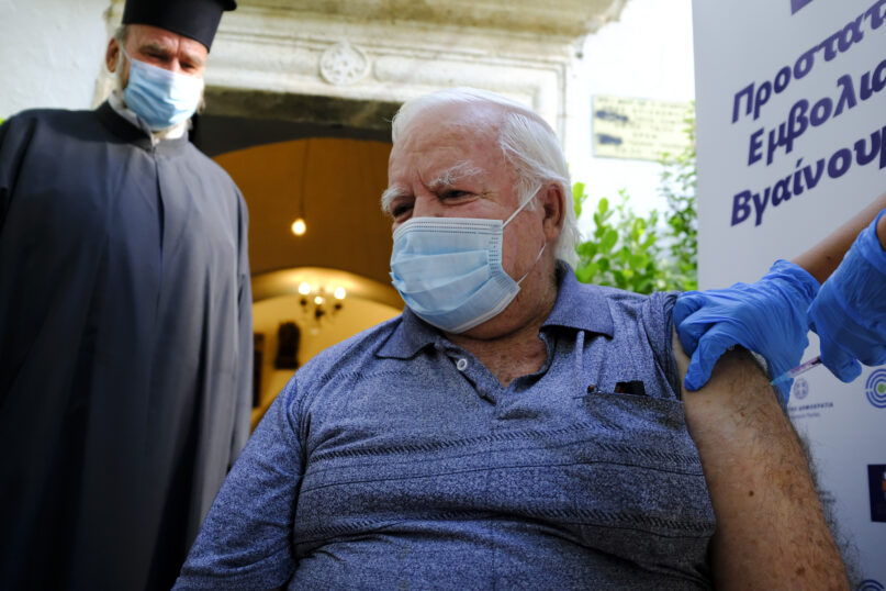Michalis Vardakis, 73,  receives a dose of the Johnson and Johnson COVID-19 vaccine, outside the church of the Virgin Mary, during a vaccination roll out, in the town of Archanes, on the island of Crete, Greece, Monday, Sept. 6, 2021. Greece has begun administering vaccinations for COVID-19 outside churches. It's a pilot program that was recently announced by the government as a means of encouraging more people to get the shots. Mobile National Health Organization units began administering shots Monday in a church yard in the town of Archanes near the city of Heraklion on the southern island of Crete.  (AP Photo/Michael Varaklas)