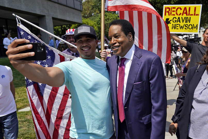 In this July 13, 2021, file photo, radio talk show host Larry Elder, center, poses for selfies with supporters during a campaign stop in Norwalk, California. (AP Photo/Marcio Jose Sanchez, File)