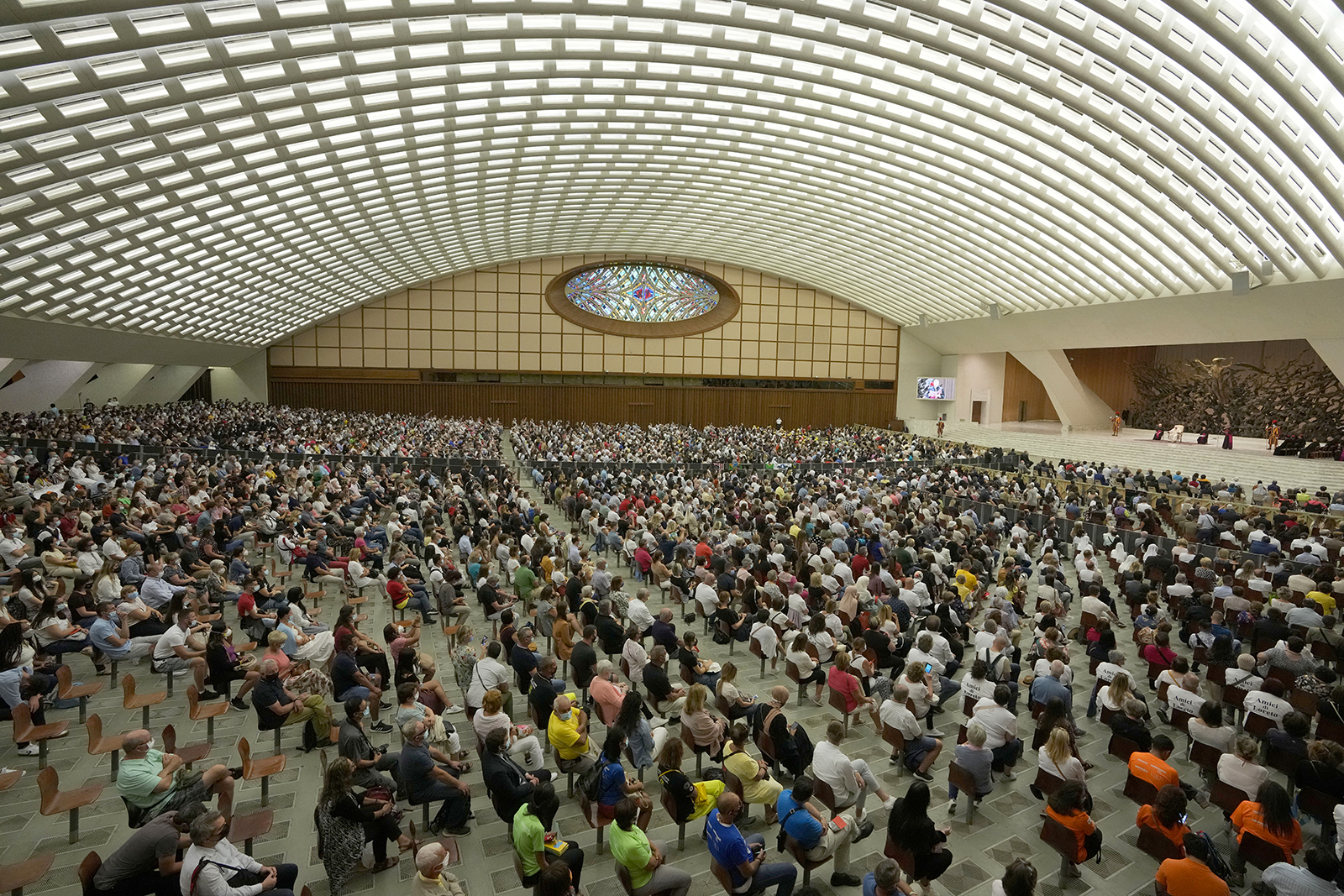 People listen to Pope Francis, white figure on stage, during his weekly general audience in Paul VI Hall, at the Vatican, Sept. 8, 2021. (AP Photo/Andrew Medichini)