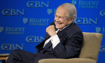 FILE - In this Feb. 24, 2016 file photo, Rev. Pat Robertson listens as Republican presidential candidate Donald Trump speaks at Regent University in Virginia Beach, Va. The Christian Broadcasting Network says Pat Robertson is stepping down as host of the long-running daily television show the “700 Club.” Robertson said in a statement that his last time hosting the network’s flagship program was Friday, Oct. 1, 2021.(AP Photo/Steve Helber, File)