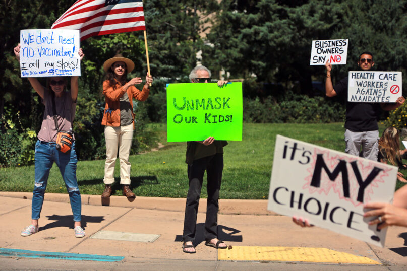 Protesters against COVID-19 vaccine and mask mandates demonstrate near the state Capitol on Friday, Aug. 20, 2021, in Santa Fe, New Mexico. (AP Photo/Cedar Attanasio)