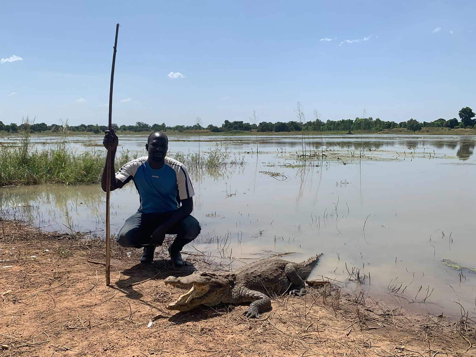 Pierre Kaboré poses with a sacred crocodile in Bazoulé, Burkina Faso, Oct. 17, 2021. RNS photo by Joseph Hammond
