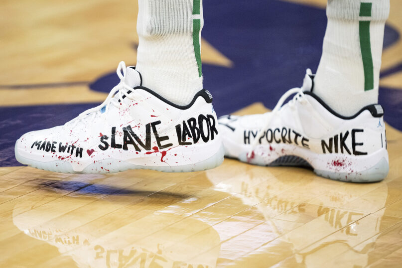 Boston Celtics center Enes Kanter wears personalized shoes during warmups before an NBA basketball game against the Charlotte Hornets in Charlotte, North Carolina, Oct. 25, 2021. (AP Photo/Jacob Kupferman)