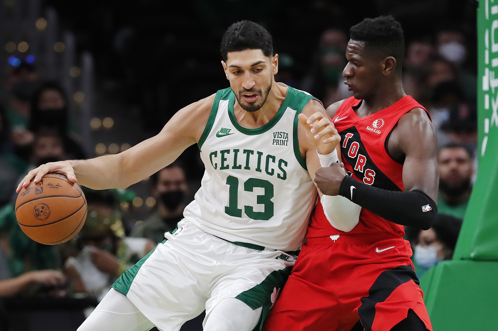Boston Celtics' Enes Kanter (13) moves against Toronto Raptors' Isaac Bonga during the second half of an NBA basketball game, Friday, Oct. 22, 2021, in Boston. (AP Photo/Michael Dwyer)