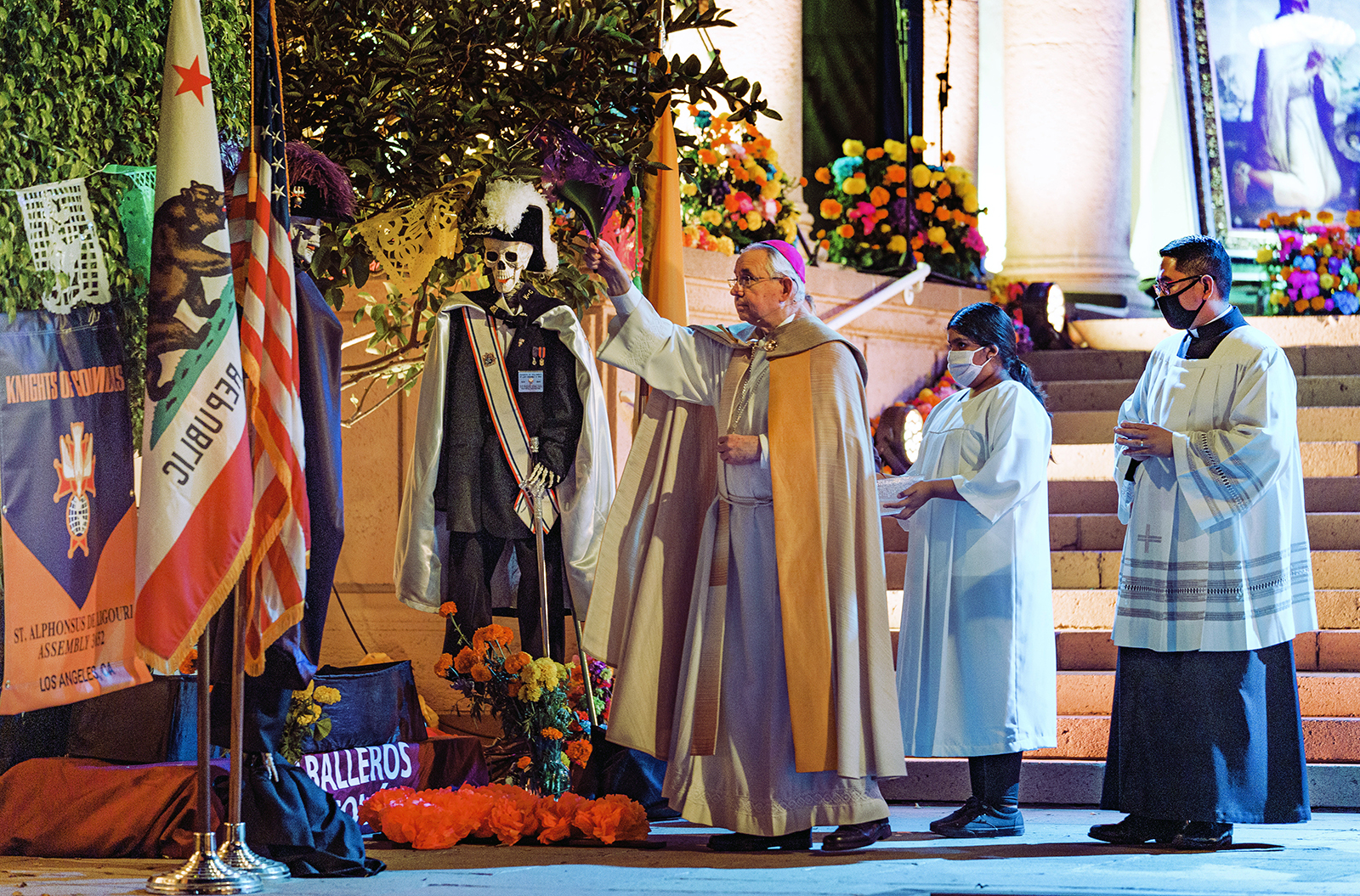 Los Angeles Archbishop José H. Gomez blesses an altar for the Knights of Columbus, Caballeros de Colon, in the outdoor courtyard of the Mausoleum of Calvary Cemetery and Mortuary in East Los Angeles, Sunday, Nov. 1, 2020. Day of the Dead, or Dia de Los Muertos, is the annual Mexican tradition of reminiscing about departed loved ones with colorful altars, or ofrendas. (AP Photo/Damian Dovarganes)