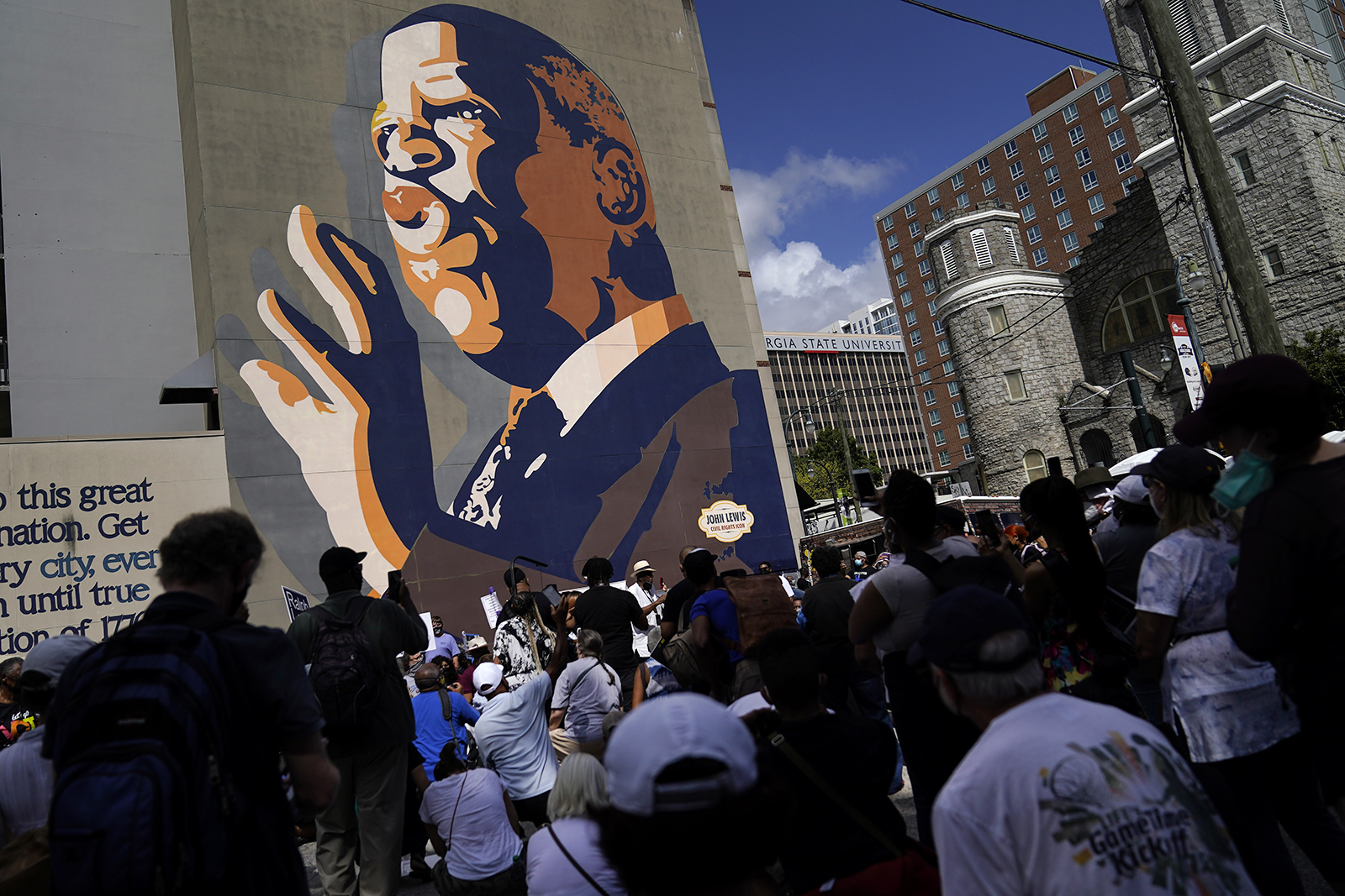 Demonstrators stop at the John Lewis Mural during a march for voting rights, marking the 58th anniversary of the March on Washington, Aug. 28, 2021, in Atlanta. Voting rights advocates have rallied across the country to call for sweeping protections against a further erosion of the Voting Rights Act of 1965. (AP Photo/Brynn Anderson)