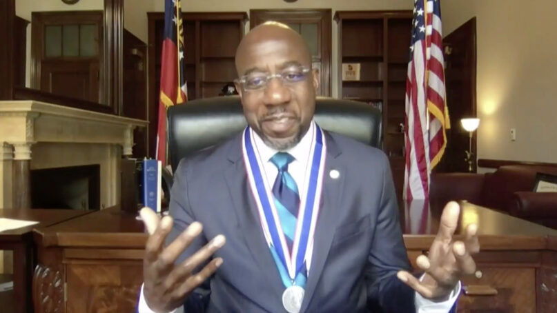 Sen. Raphael Warnock speaks after receiving the Roosevelt Institute’s Freedom of Worship Award, Wednesday, Oct. 13, 2021, during a virtual ceremony. Video screengrab