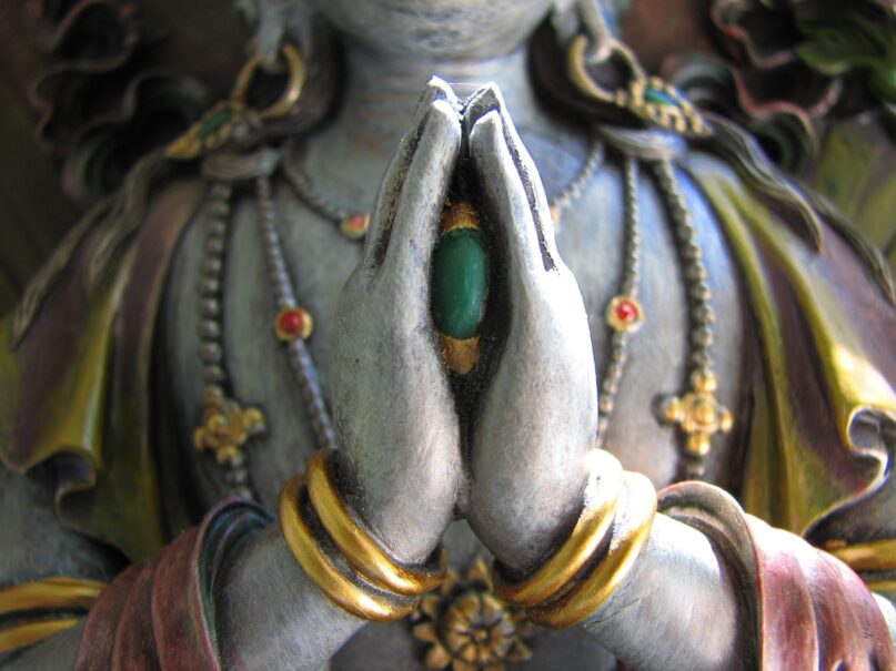 Avalokiteshvara, the bodhisattva of compassion, holding a jewel between his folded hands. (Debbie Hemenway/Moment via Getty images)