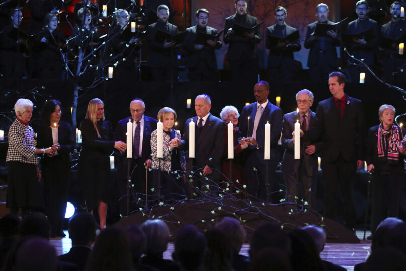 FILE - Survivors stand on the stage during the candle lighting, during the national UK Holocaust Memorial Day Commemorative Ceremony at Central Hall Westminster in London, Monday, Jan. 27, 2020.   A new survey has found what organizers say is a lack of awareness in Britain about the Holocaust and the country's rescue of Jewish children ahead of World War II. The Claims Conference said Wednesday, Nov. 10, 2021, that 52% of respondents surveyed in the U.K. did not know that 6 million Jews were murdered by the Nazis. (Chris Jackson/Pool via AP, File)